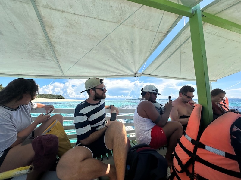 "Blick am Boot. Sophia schaut aufs Handy, ich schaue vorwärts, Miguel macht ein Foto."