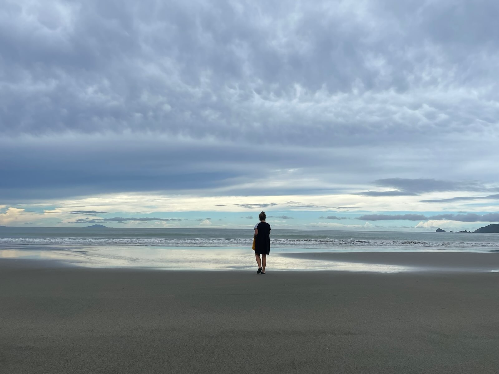 "Sophia steht am Strand, vor ihr das Meer. Am Horizont erkennt man in der Ferne einen Berg, und etwas weiter rechts am Rand, einige Klippen."