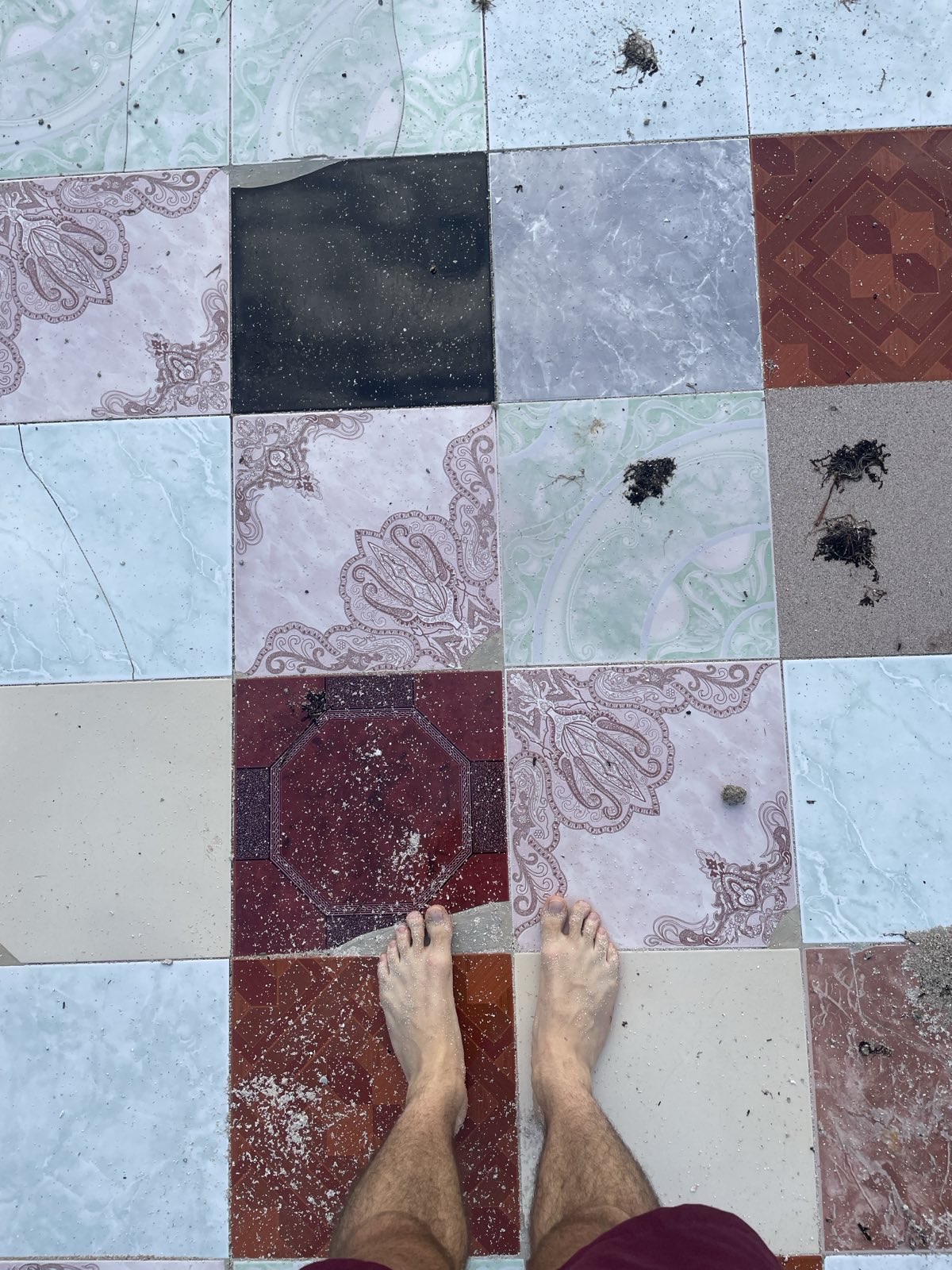 "Ich stehe barfuß auf einigen bunten Fließen."