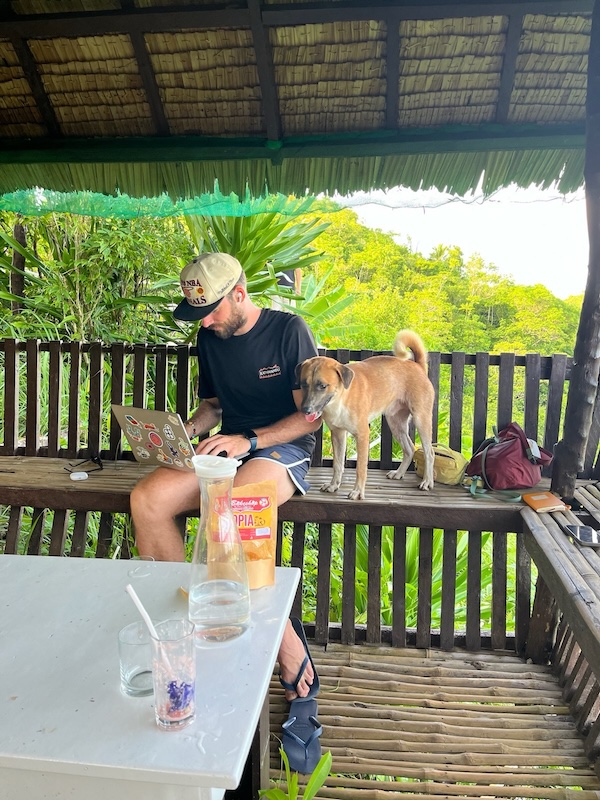 "Ich sitze in der Holzhütte, mit Laptop am Schoß. Ich sehe konzentriert aus. Neben mir auf der Holzbank sitzt ein Hund."