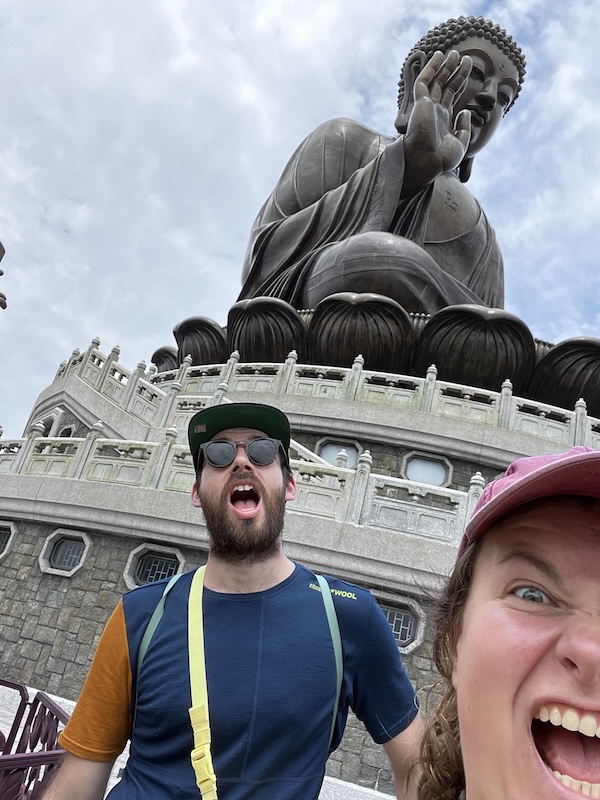 "Die große Buddha-Statue. Davor posieren Sophia und ich. Wir beide haben zur Belustigung den Mund weit aufgerissen."