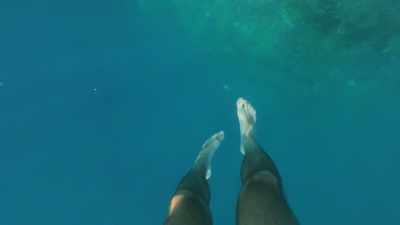 "Meine Beine im tiefblauen Wasser. Unter mir erkennt man nur die Tiefe des Ozeans"