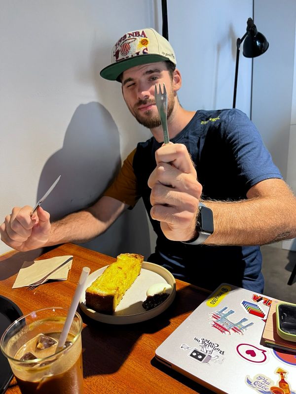 "Ich sitze am Tisch, halte eine Gabel hoch und zwinkere in die Kamera. Vor mir ist ein Teller samt Brot und ein Glas mit Eiskaffee."