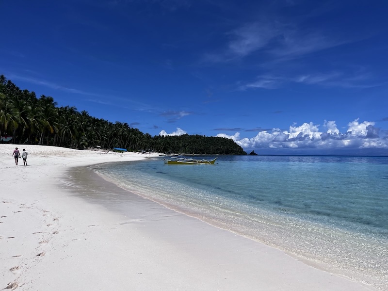 "Ein weißer Sandstrand und ein türkis-blaues Meer."
