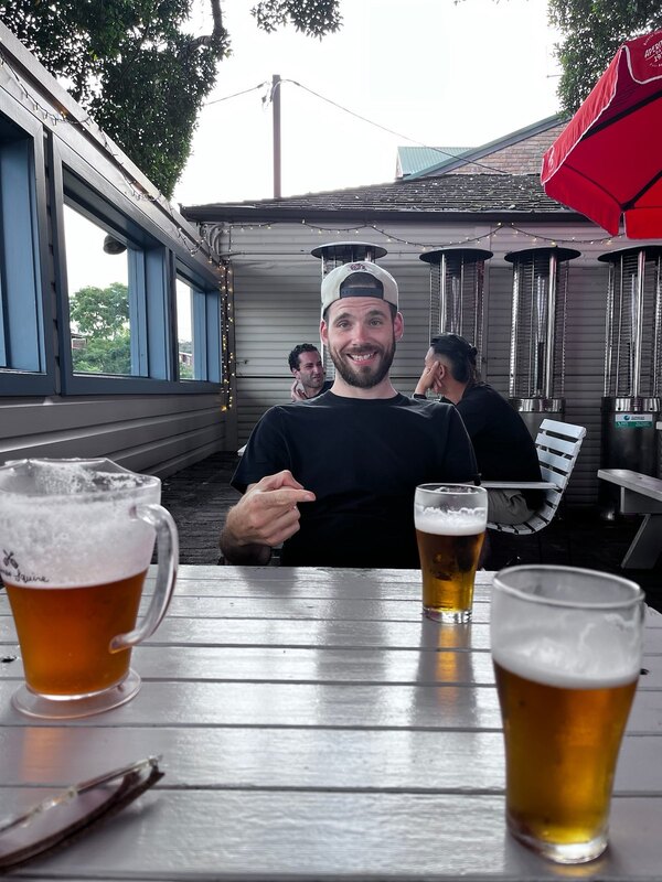 "Ich grinse, wie ich mit meinem Finger auf mein Glas Bier zeige. Am Tisch des Gastgartens steht ein Krug und ein zweites Glas Bier."