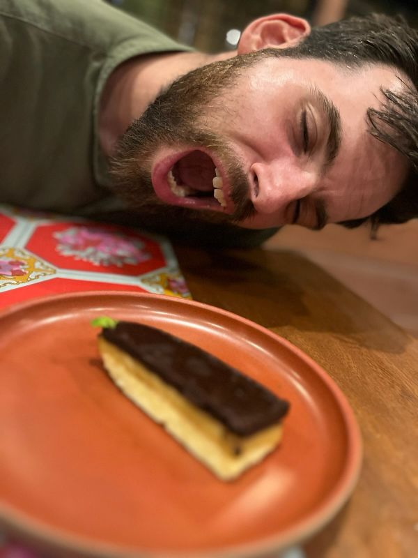 "Ein Teller mit cremigen Schokokuchen, darüber lehne ich mich und öffne den Mund, als würde ich den Kuchen gleich in einem Biss verschlingen"