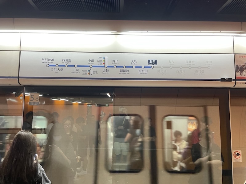 "Die U-Bahn fährt ein. An der Glaswand reflektiert erkennt man eine geordnete Reihe von Menschen und meinen Oberkörper."