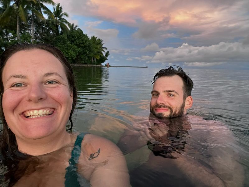 "Sophia und ich im Wasser. Sophia grinst breit, ich halte meine Hände an meine Brust und lächle."