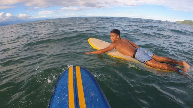 "Chad im Meer, wie er auf seinem gelben Surfbrett an mir vorbei paddelt."