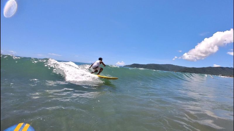 "Chad surft eine Welle, Teil 1: Er steht in den Knien auf der Welle und blickt geradeaus."
