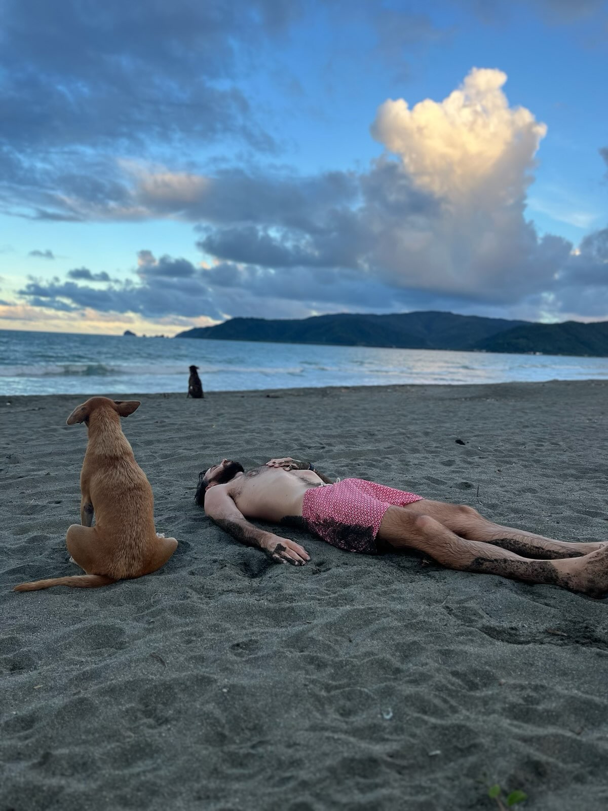 "Komplett erledigt liege ich mit Badehose im weichen Sandstrand. Vor lauter Anstrengung lege ich meine Hand auf die Brust. Neben mir sitzt Kabud, der blonde Hund und schaut aufs Meer."