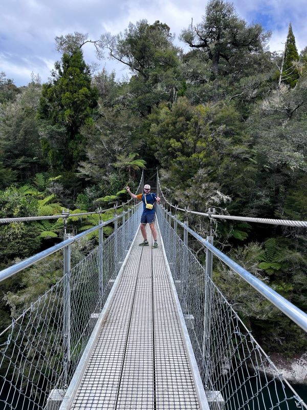 "Ich stehe auf einer Hängebrücke im Nationalpark und habe meine Hände in der Luft, als würde ich tanzen. Hinter mir ist das grüne Dickicht des Waldes."